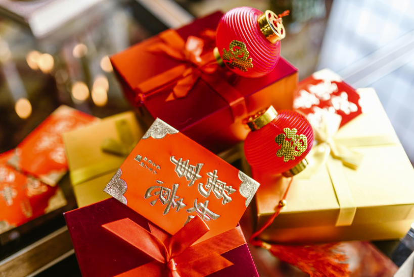 Chinese New Year gift boxes decorated in red and gold, along with traditional red lantern ornaments.