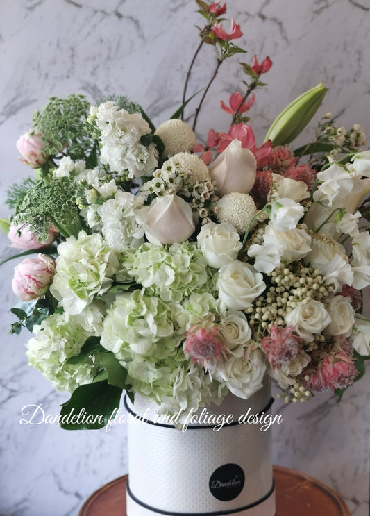 This mega tall flower hat box is perfect gift to express loads of big love!! This stylish mega arrangement is a perfect way to show off an array of stunning soft pink, white and green fresh blooms.