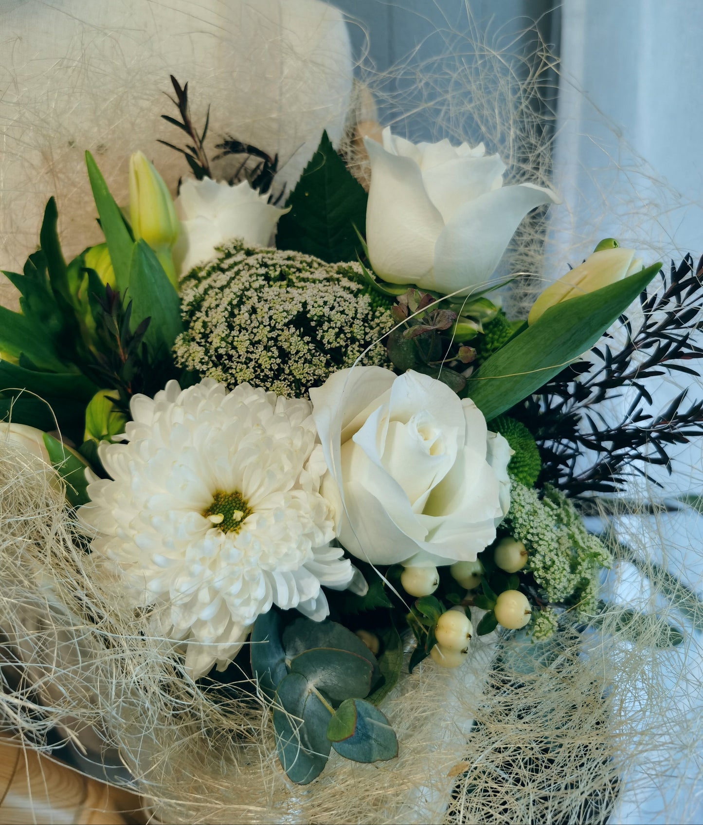 The white and green bouquet features fresh and seasonal blooms in shades of white/cream/ivory, greens and neutral colours. It will make an ideal gift to express your love, gratitude or congratulation.