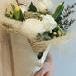 The white and green bouquet features fresh and seasonal blooms in shades of white/cream/ivory, greens and neutral colours. It will make an ideal gift to express your love, gratitude or congratulation.