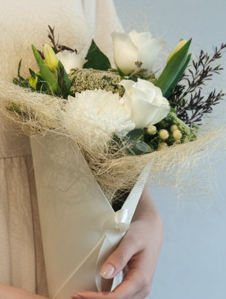 The white and green bouquet features fresh and seasonal blooms in shades of white/cream/ivory, greens and neutral colours. It will make an ideal gift to express your love, gratitude or congratulation.