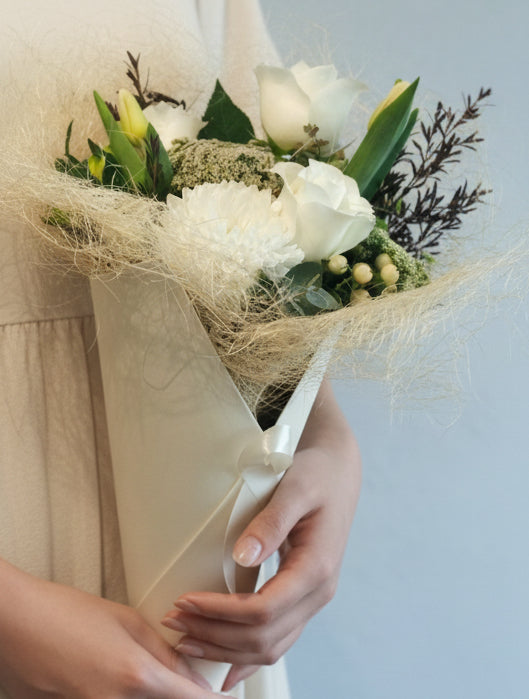 The white and green bouquet features fresh and seasonal blooms in shades of white/cream/ivory, greens and neutral colours. It will make an ideal gift to express your love, gratitude or congratulation.