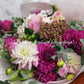 Graduation bouquet in a combination of white, pastel tones using seasonal flowers and greenery.
