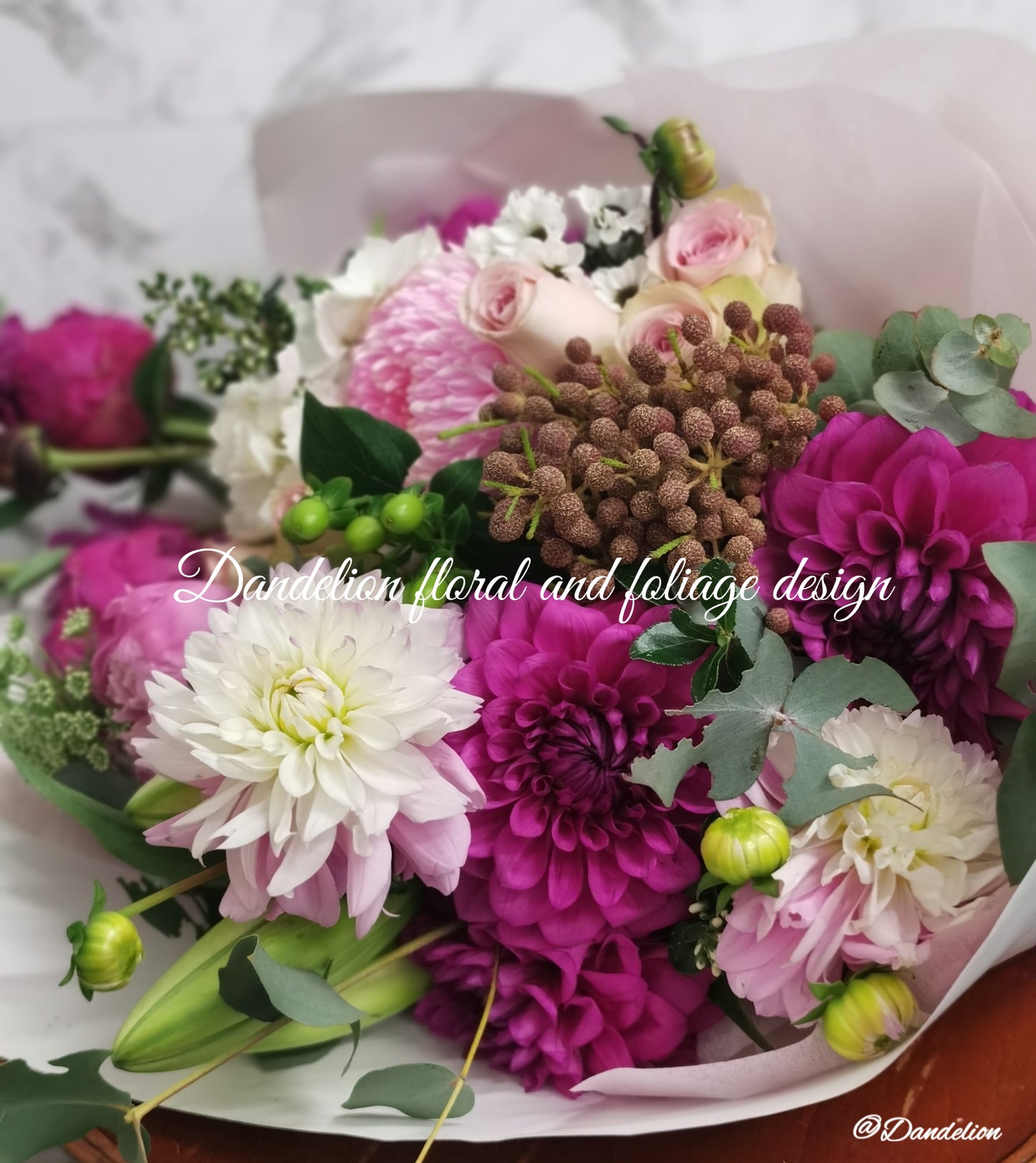 Graduation bouquet in a combination of white, pastel tones using seasonal flowers and greenery.
