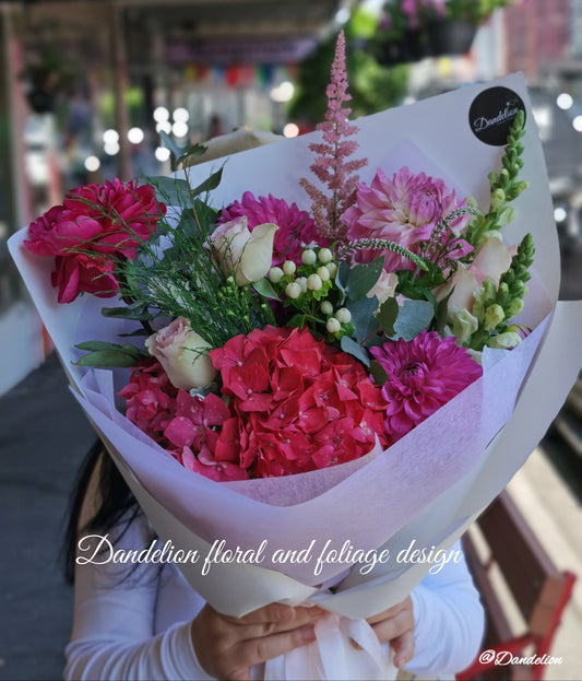 Graduation bouquet in a combination of white, pastel tones using seasonal flowers and greenery.