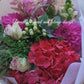 Graduation bouquet in a combination of white, pastel tones using seasonal flowers and greenery.