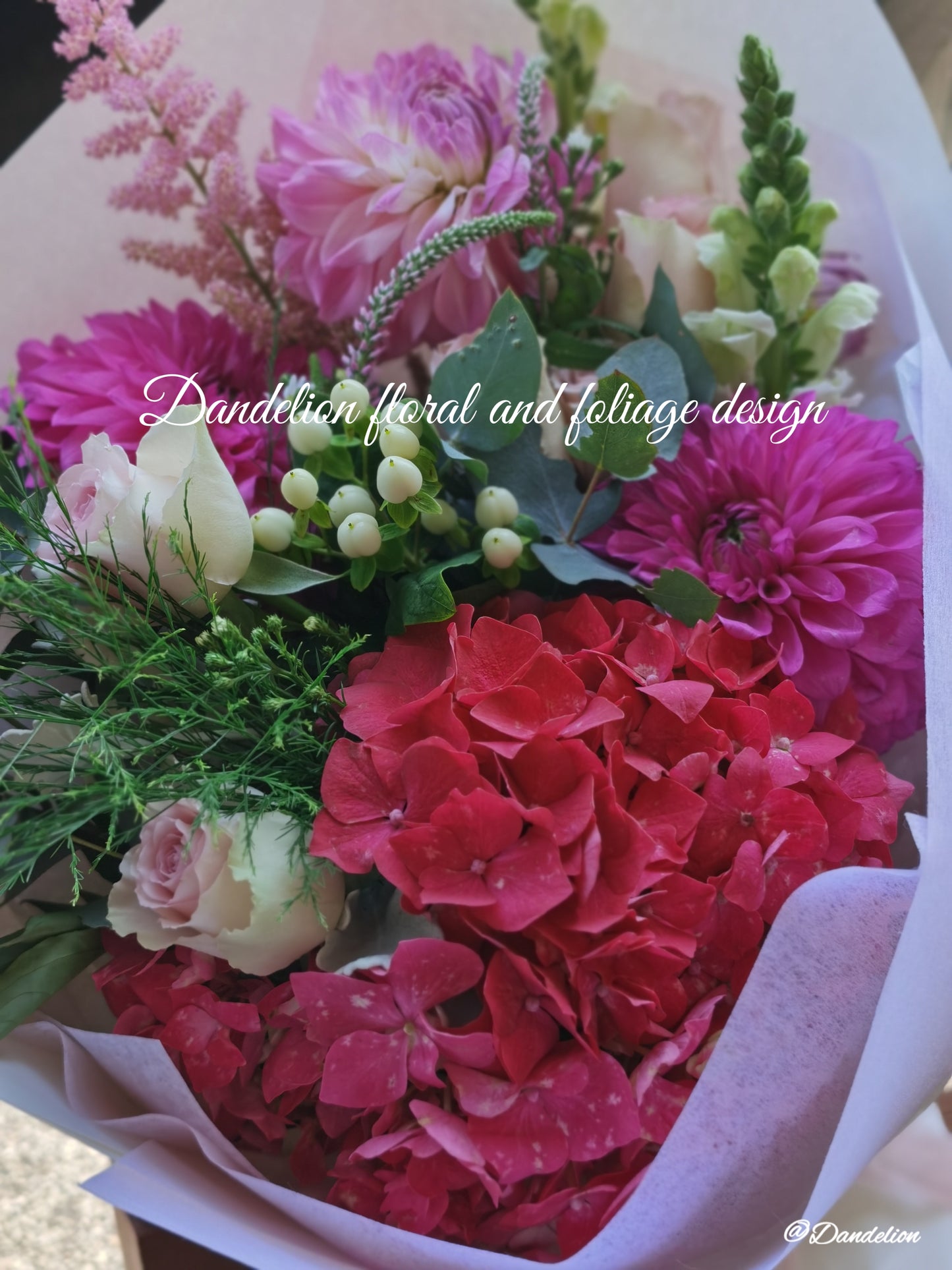 Graduation bouquet in a combination of white, pastel tones using seasonal flowers and greenery.