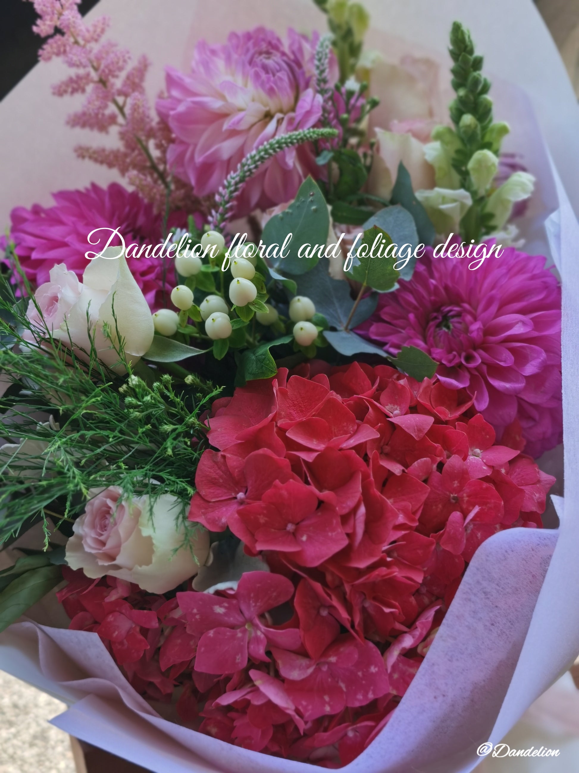 Graduation bouquet in a combination of white, pastel tones using seasonal flowers and greenery.
