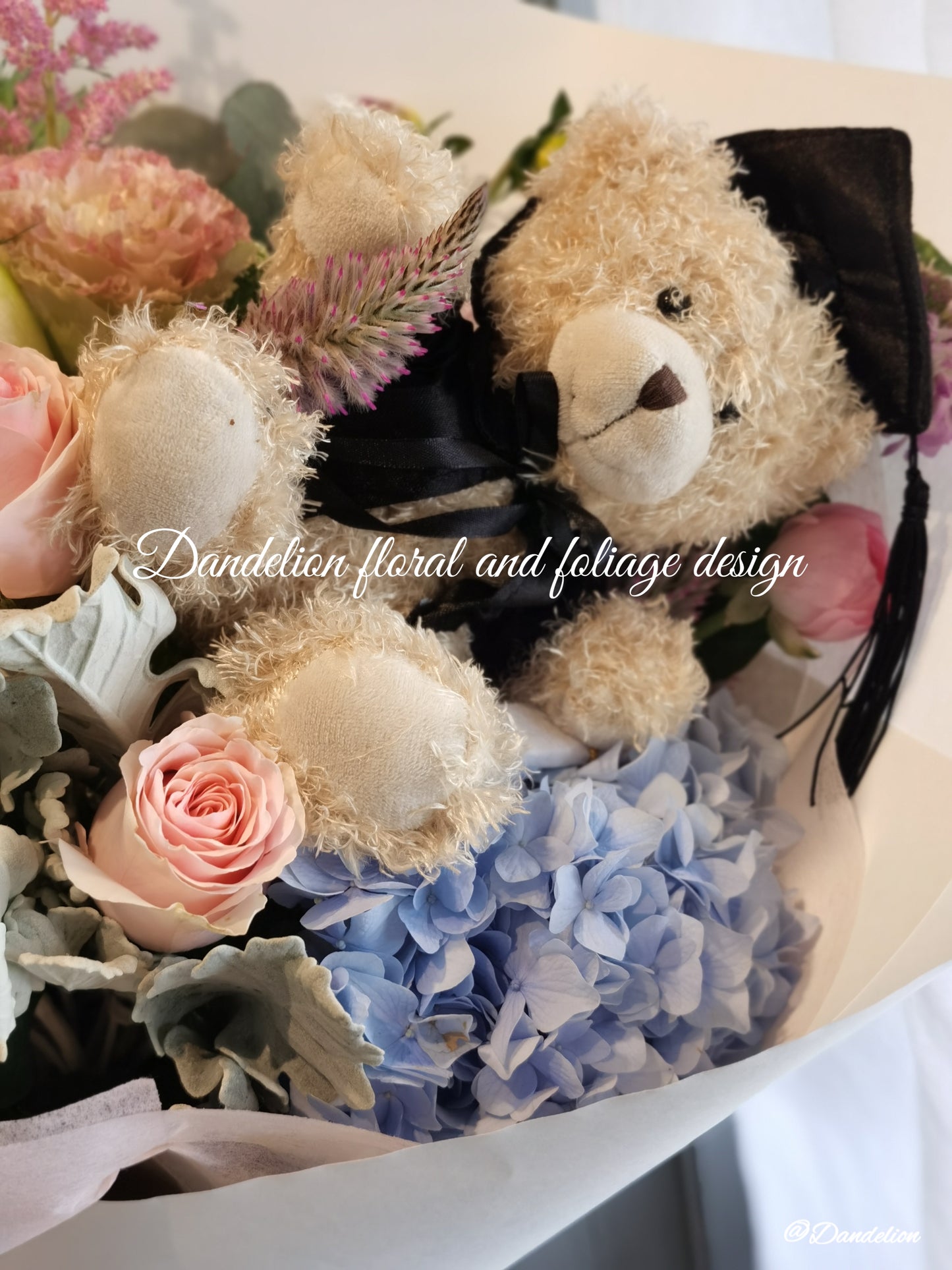 A graduation bouquet featuring a mix of pastel colored flowers and greenery, wrapped with a ribbon, alongside a plush toy bear. Lush bouquet using seasonal blooms in pastel tones complimented with seasonal greenery.
Our Graduation Flowers are the perfect way to send your best wishes and honour their hard work and dedication. With an added special touch our graduation bear - the perfect keepsake.