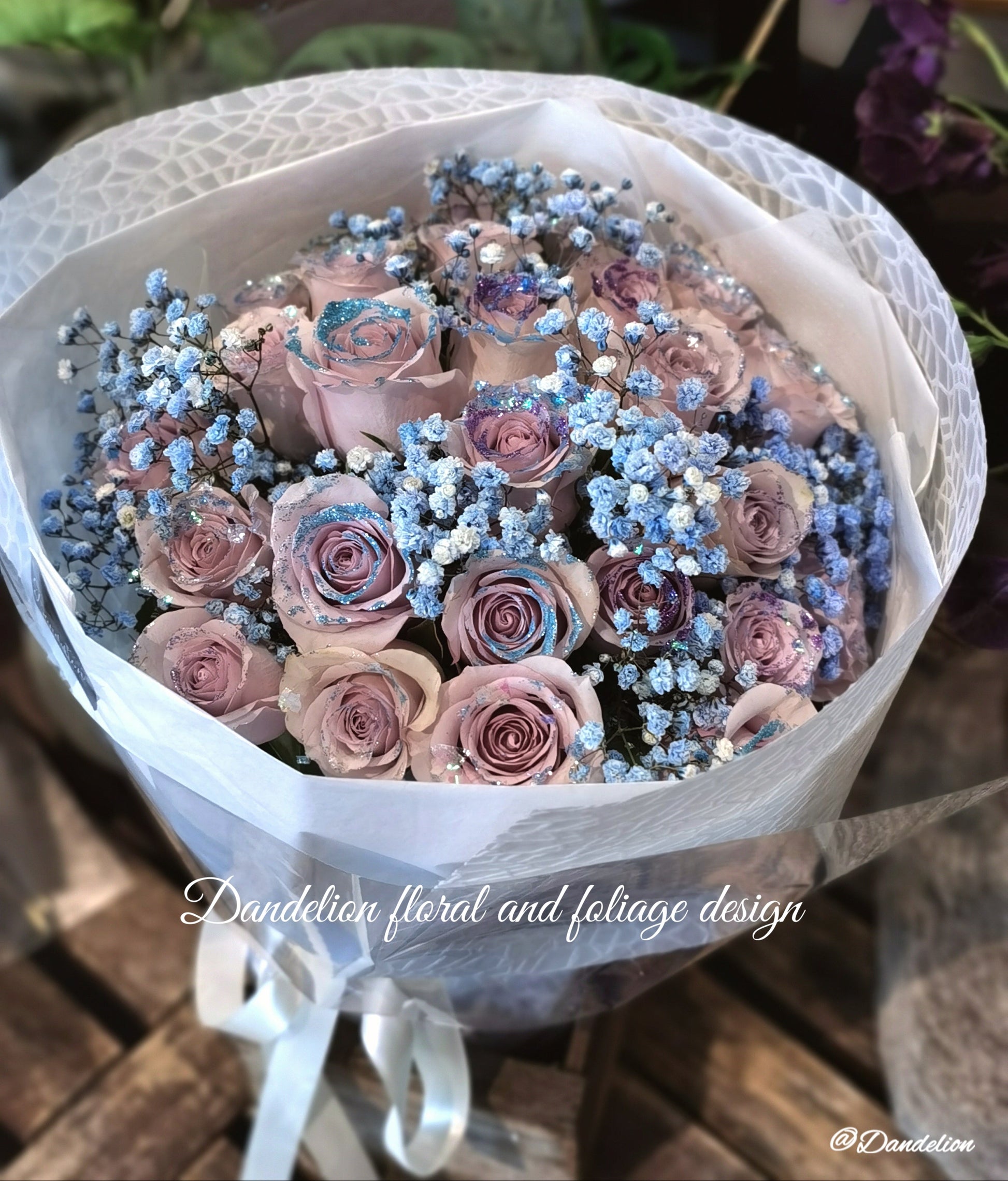 A bouquet of mauve color roses with a shining texture, held by a mannequin. The bouquet features a mix of large and small roses, and is complemented by blue accents in the form of flower beads. 36 stems of&nbsp;premium 40cm mauve colour roses with Shining texture.
Whether impressing a new love, proposing to someone or simply to say "I love you", this&nbsp;special bouquet will take their breath away.
Available in 36 stems(classic), 48 stems(Large) and 60 stems(Deluxe)
