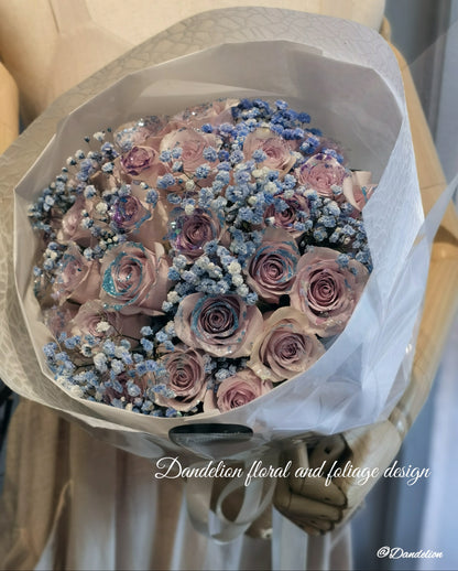 A bouquet of mauve color roses with a shining texture, held by a mannequin. The bouquet features a mix of large and small roses, and is complemented by blue accents in the form of flower beads. 36 stems of&nbsp;premium 40cm mauve colour roses with Shining texture.
Whether impressing a new love, proposing to someone or simply to say "I love you", this&nbsp;special bouquet will take their breath away.
Available in 36 stems(classic), 48 stems(Large) and 60 stems(Deluxe)