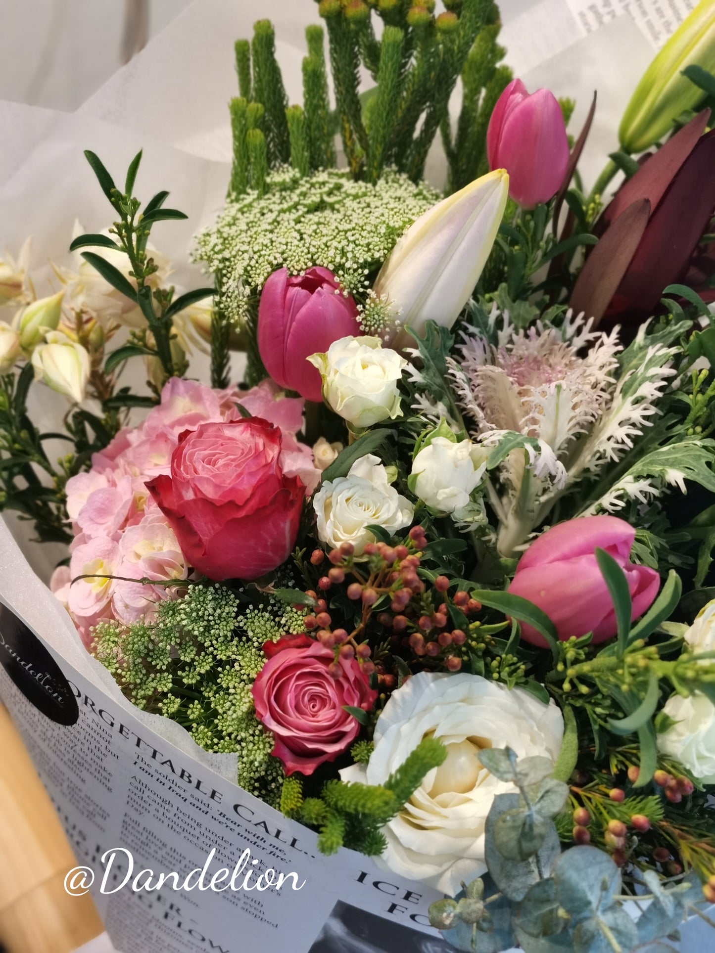 Soft pastel flower bouquet featuring roses and lilies in light pink and cream tones, hand-wrapped