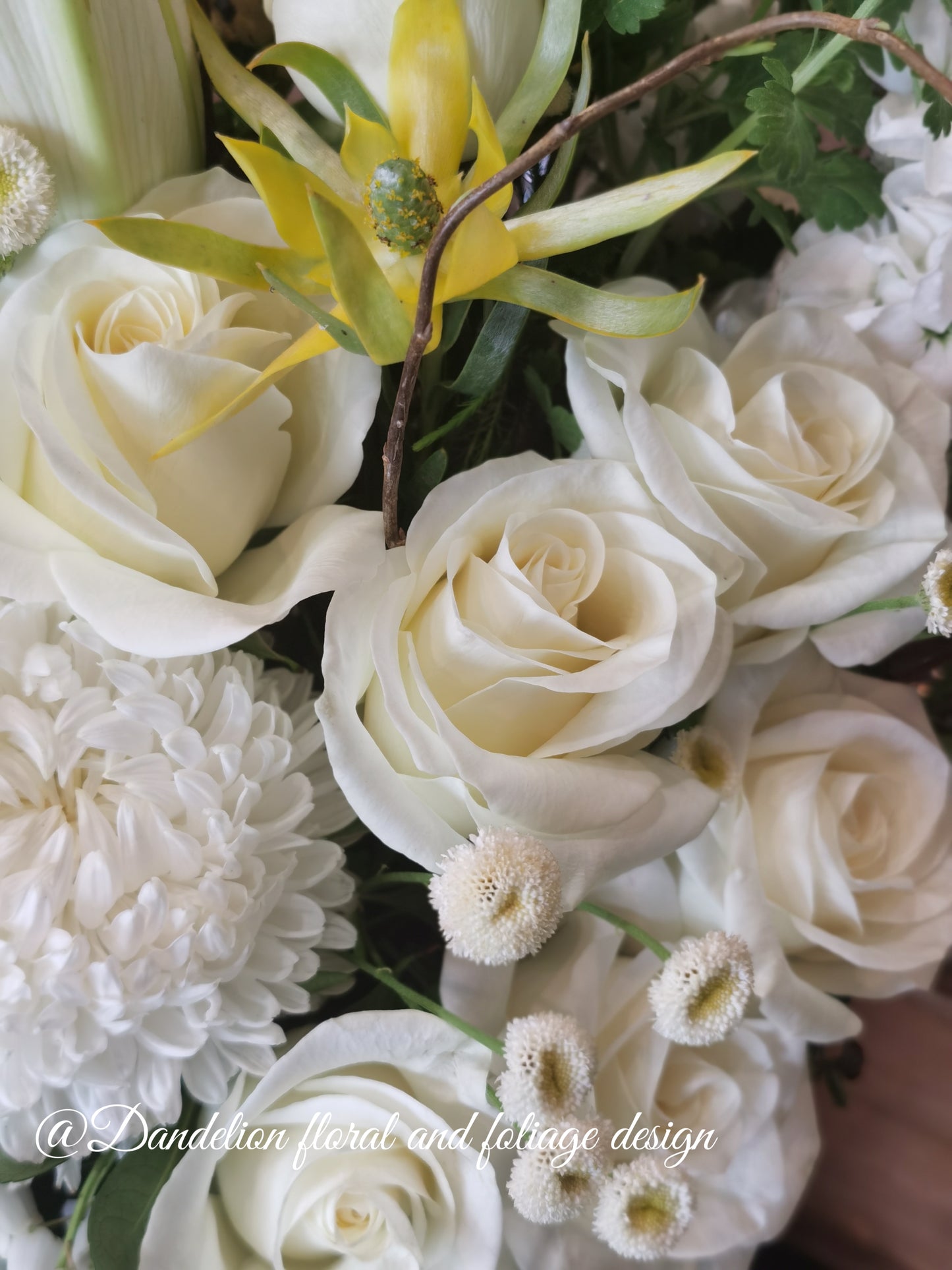 A round tall white hat box filled with white and green flowers, arranged white classic yet in a modern shape. Wedding, engagement or a sad occasion, this arrangement will fulfill what you are in need for.