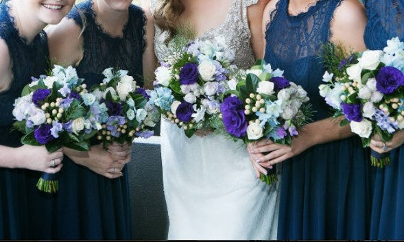Bride with four bridesmaids holding bouquets in a celebratory setting.