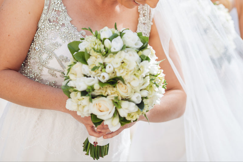 Bride holding a bouquet of flowers with two other women in the background.