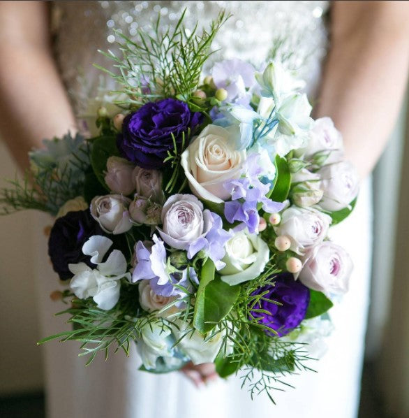 Bouquet of flowers held by a person, with a blurred background