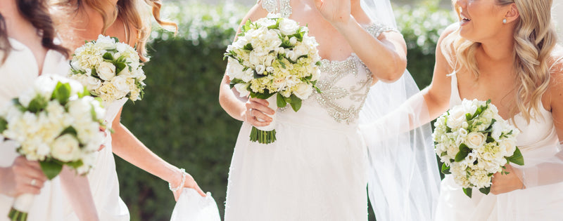 Bride and bridesmaids posing outdoors with bouquets