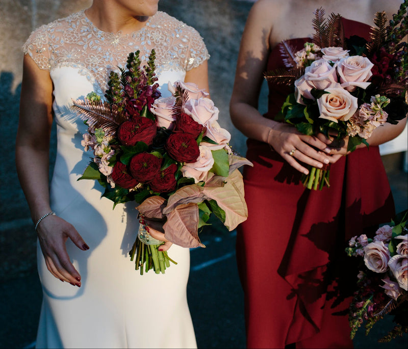 Two women holding wedding bouquets with a blurred background