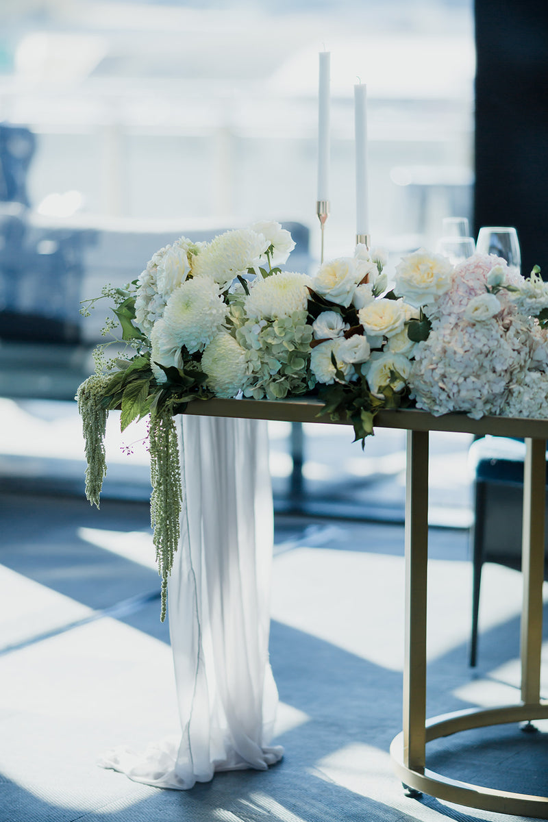 Decorative table with roses and white flowers and candles on a clear day for wedding