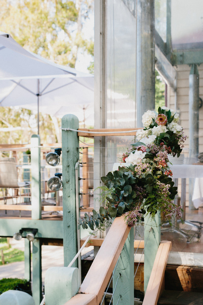 Decorative floral arrangement on a chair with a blurred outdoor setting for luxury wedding