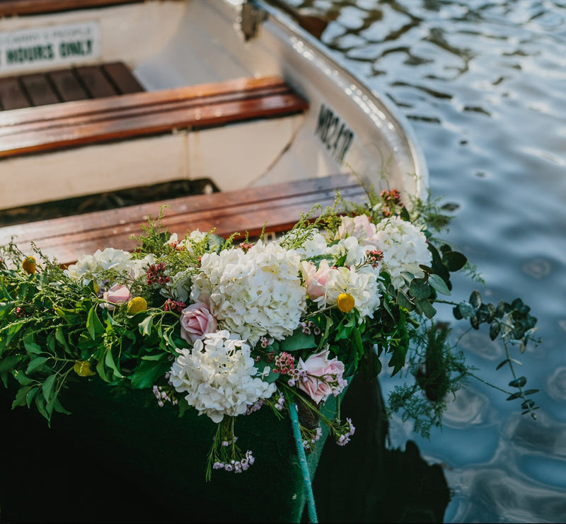 Decorative flowers on a boat with water in the background