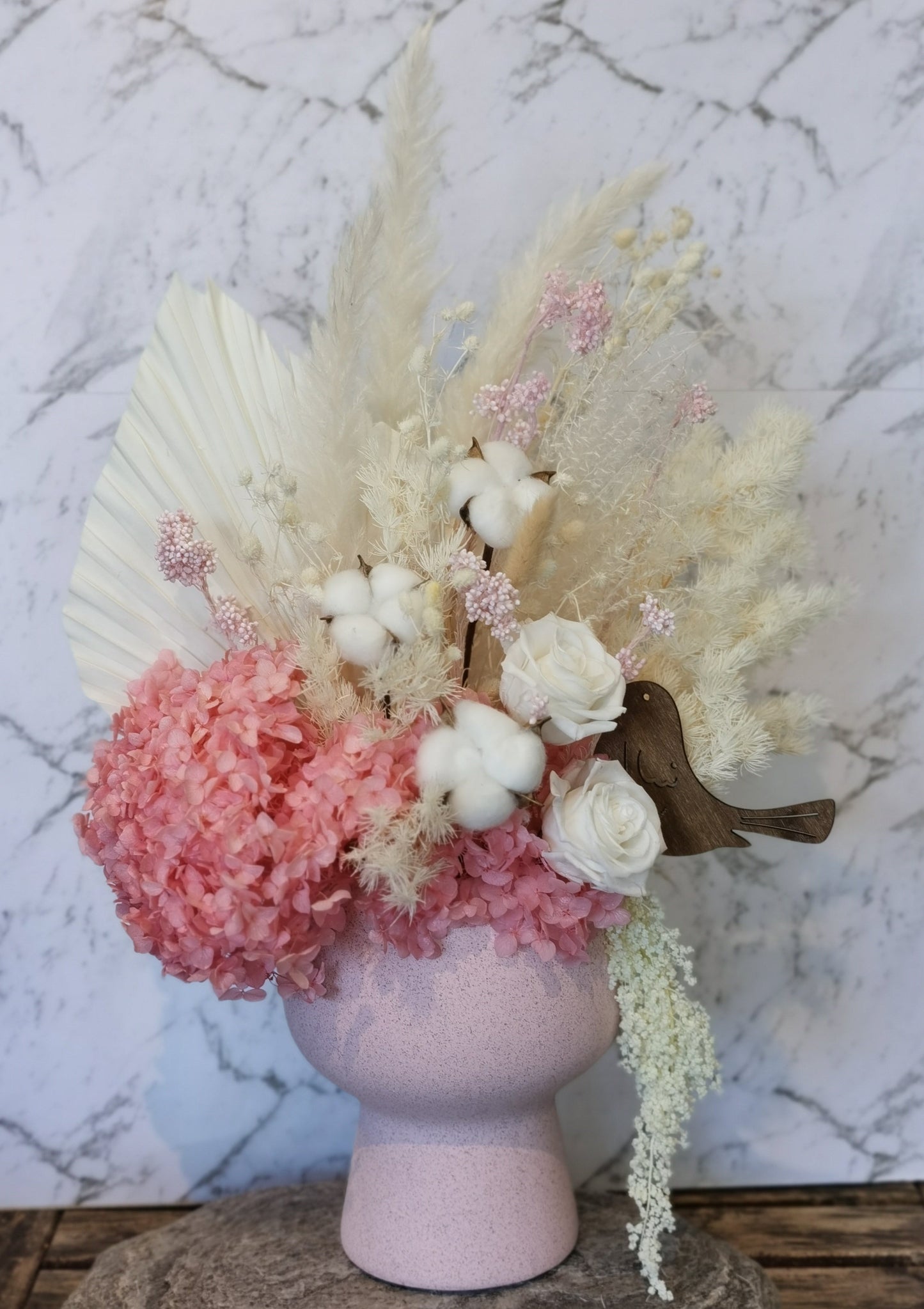 This Large pink arrangement will suit any display with its&nbsp;white and pink colours. This gorgeous arrangement in an antique looking pot is made from a wide range of beautiful preserved &amp; dried flowers which consists of: Hydrangea, Roses, Rice flowers, Seaholly, Ruscus, Bunnytale, Billy button and more.