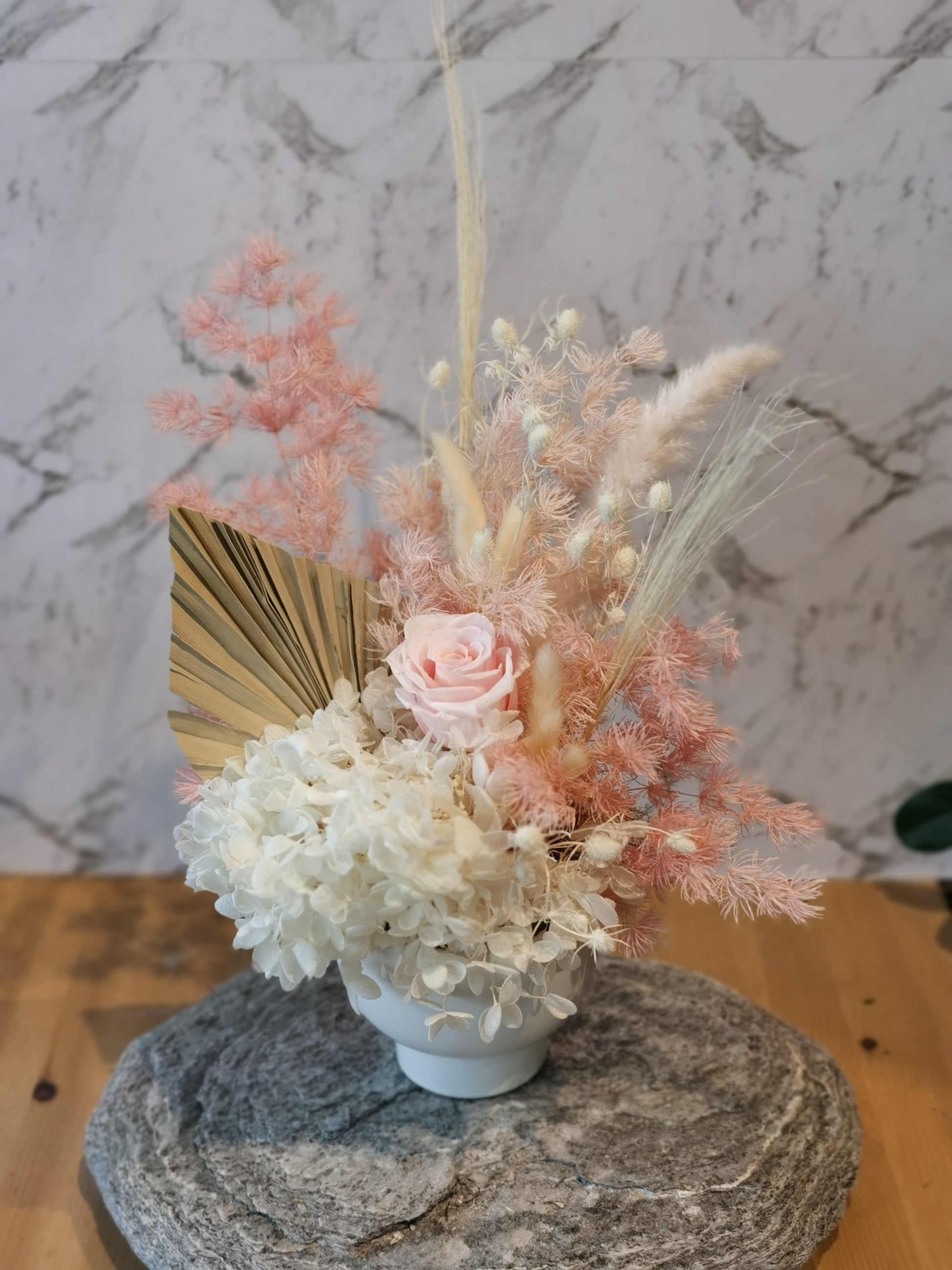 This gorgeous mini arrangement in an antique looking pot is made from a wide range of beautiful preserved &amp; dried flowers which consists of: Hydrangea, Rose, Seaholly, Bunnytale, and more.
It comes with white ceramic pot.&nbsp;